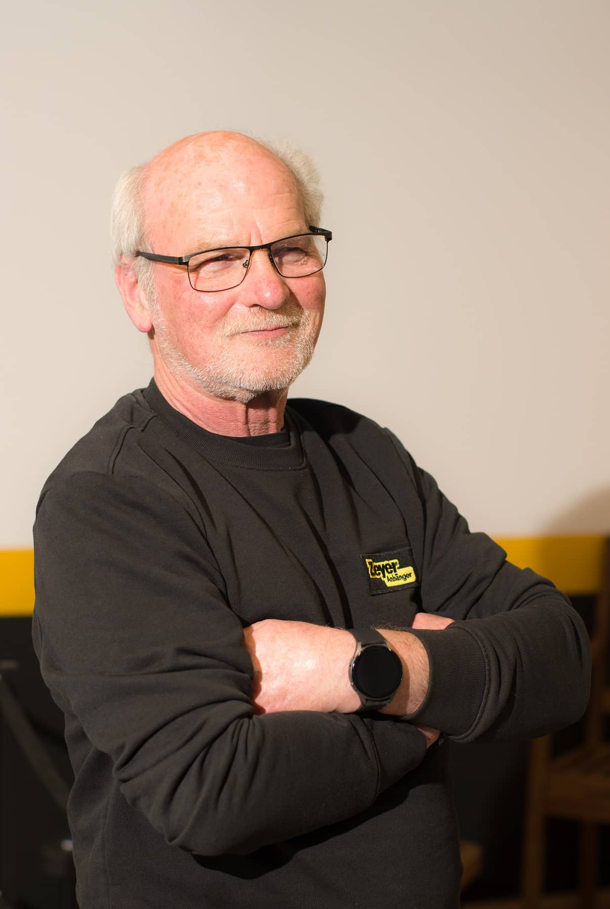 Älterer Mann mit Brille und schwarzem Pullover